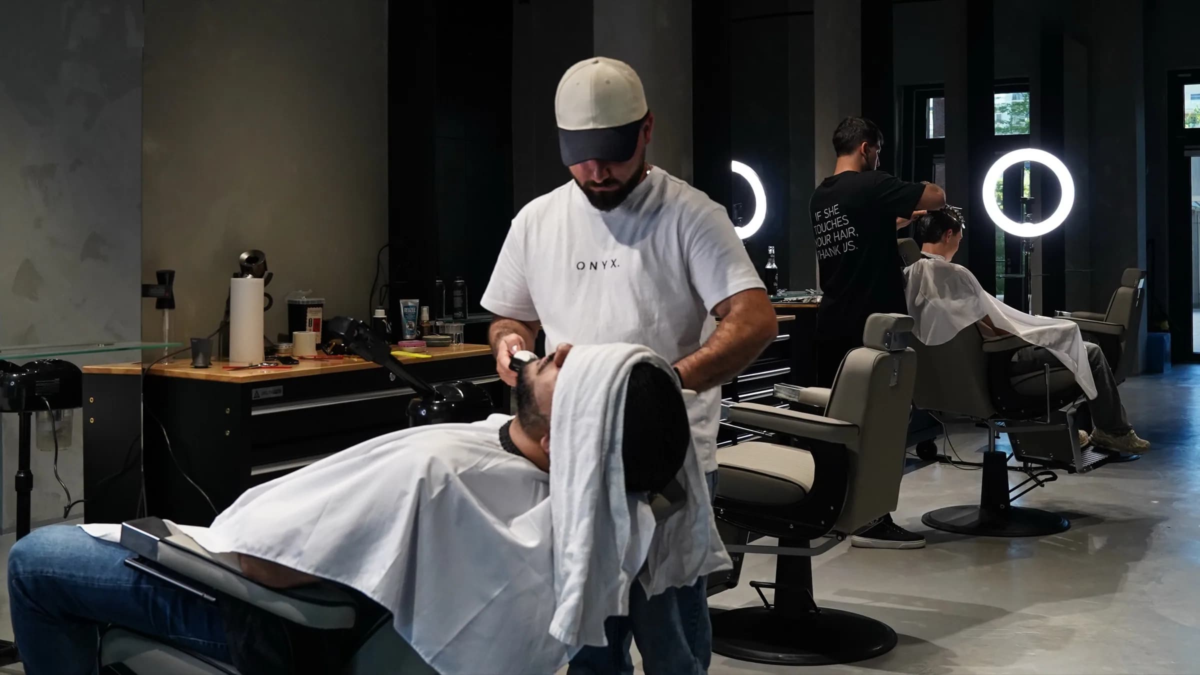 Barber bei ONYX Cuts in Wien rasiert einen Kunden mit heißem Tuch